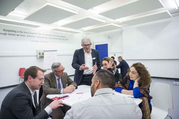 Gruppenbesprechung an einem Tisch mit dem Lehrer