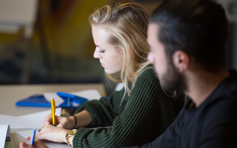 Une étudiante concentrée en accomplissant un exercice