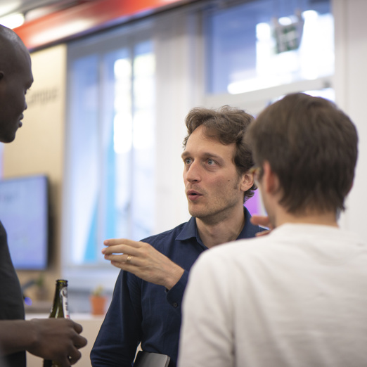 Un homme qui parle à trois autres hommes du groupe Innovation Club